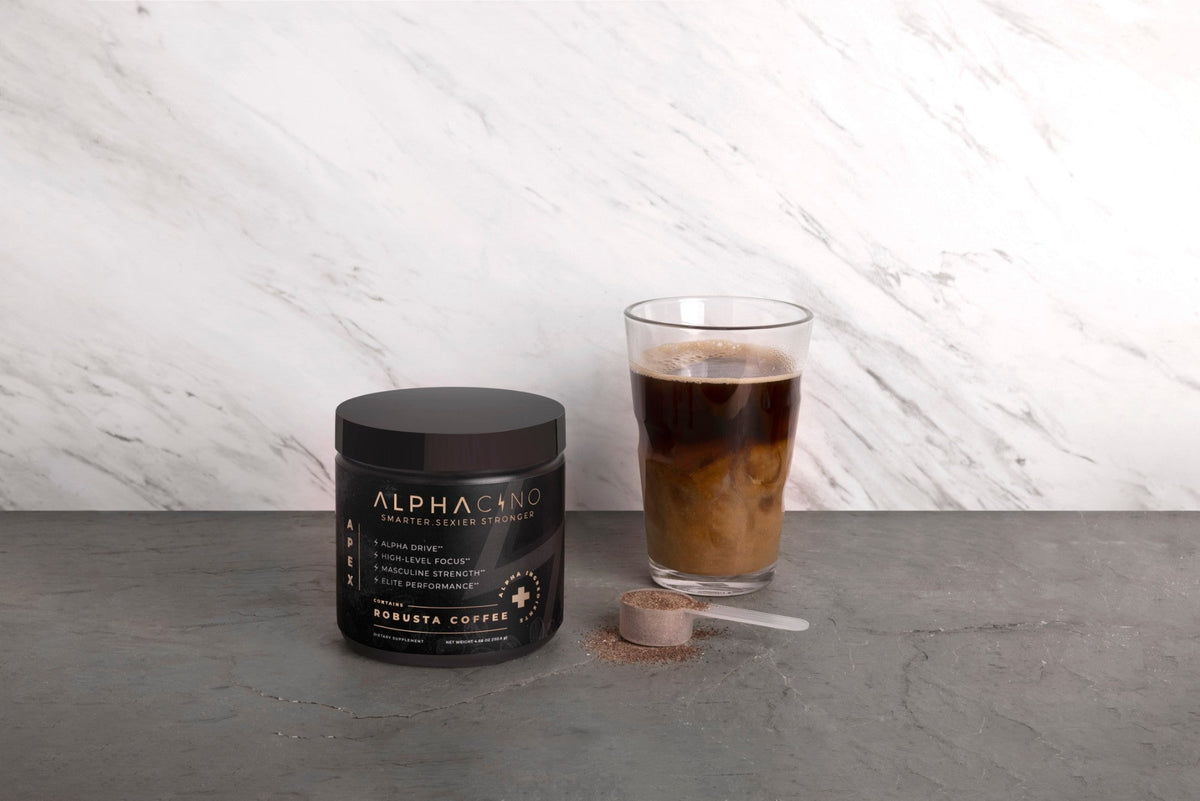 A jar of Alphacino robusta mushroom coffee beside a glass of iced coffee with milk and a scoop of the powder on a stone counter